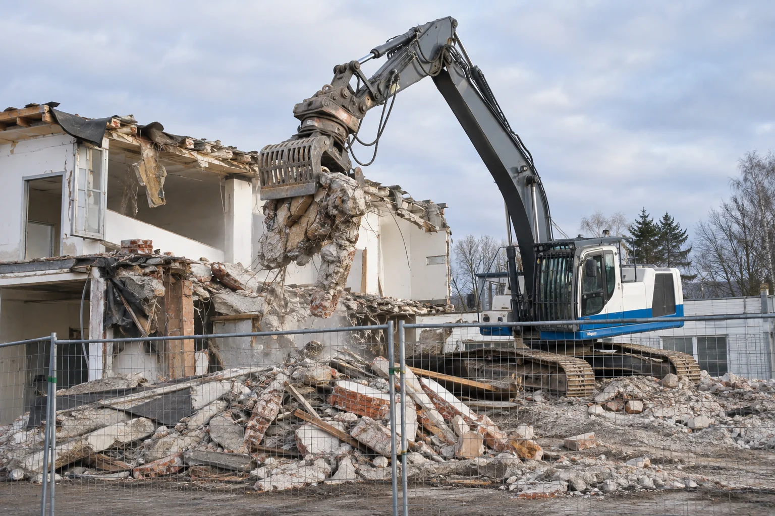 Bagger beim kontrollierten Rückbau eines Gebäudes